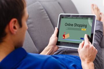 Internet shopping man online with tablet pc and credit card. Internet shopper buying things on the internet showing blank tablet pc computer as sign. Multicultural Asian Caucasian model happy