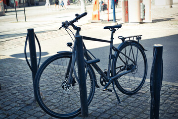 Naklejka na ściany i meble A black bicycle parked in the city