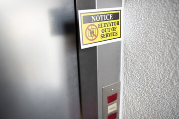 yellow elevator out of service notice sign attached to elevator door, digital composite