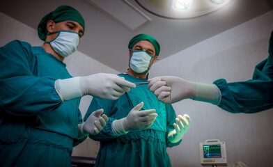 Fototapeta na wymiar Team of doctors surgeons wearing safety uniform , medical masks and preparing preferment operation in operating room for patient at hospital
