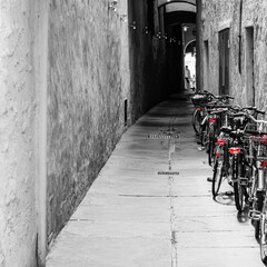 Bicycles in an alleyway in Bolzano, Italy.  Spot colour.