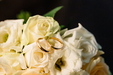 Wedding rings of the bride and groom on the background of a bouquet