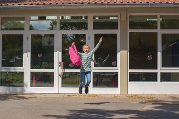 The schoolgirl is jumping for the joy of returning to school. The beginning of the school year....