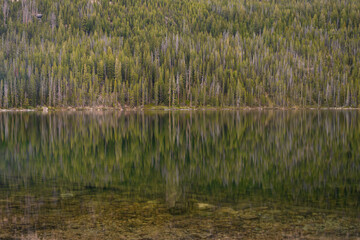 Reflecting waters of hell roaring lake in the sawtooth mountain range of central Idaho