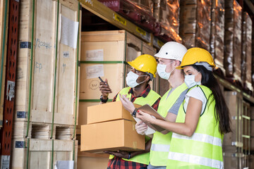 Group of worker wear safety helmet and mask working in warehouse.