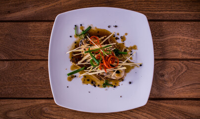 Steam fish with soy sauce is a clean food for good health. Presents in a flat lay, top view, copy space on wooden background.