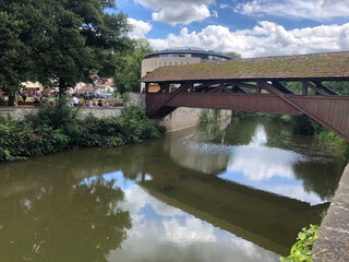 Schwäbisch Hall, Germany - July 11, 2020: Medieval wooden bridge over the river Kocher in Schwaebisch Hall, Baden-Wuerttemberg, Germany