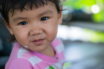 A little girl with a smiling face, three years old, ASEAN people are eating.