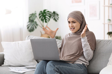 Computer problems. Angry arab woman having issues with laptop at home
