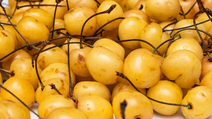A lot of yellow cherries on sale at farms market. Defocused background. Harvest concept. Sweet...