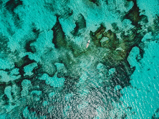 Turquoise ocean water and fisherman on boat. Top view