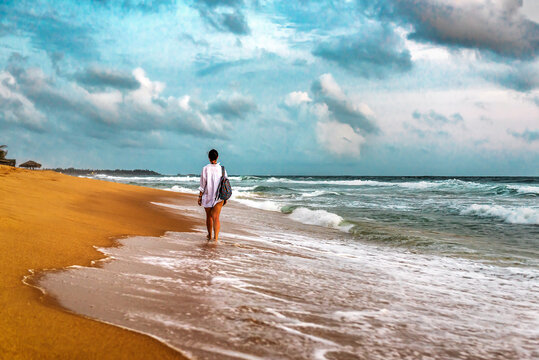 girl in white walks on the beash