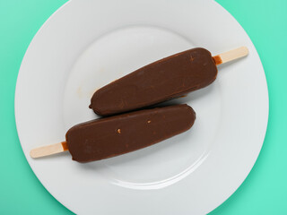 top view two chocolate flavor popsicles on a dish