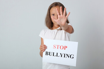 Sad girl holding a stop bullying sign
