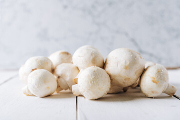 Several mushrooms on a white wooden background