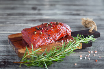 Whole beef meat raw tenderloin steak, rosemary, pepper, sea salt on wooden board