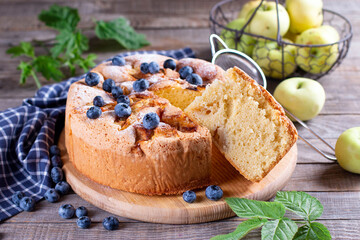 Apple pie, sponge cake, Charlotte with with apples and blueberries on a wooden table
