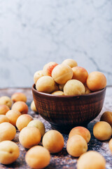 Lots of ripe yellow apricots close up in a crockery on the table