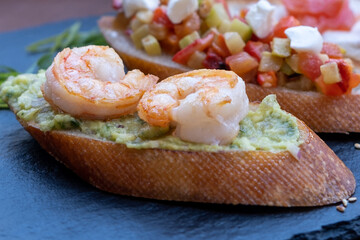 Bruschetta with shrimps, vegetables, salmon. Restaurant snacks.