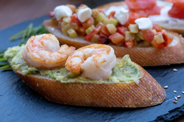 Bruschetta with shrimps, vegetables, salmon. Restaurant snacks.