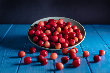 Natural ripe cherries falling out from plate. Summer fruits photographed in studio