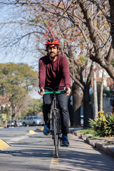 Young man cycling on his city bike with his helmet