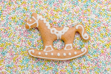 Lebkuchenpferd mit Zuckerguss und vielen bunten Liebesperlen als Hintergrund