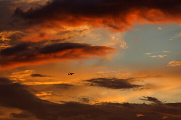 Plane on red sky in sunset