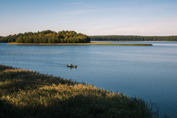 Angler in a boat on the Wigry lake near Wigierski National Park, Podlaskie, Poland