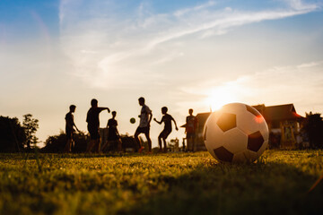 Silhouette action sport outdoors of kids having fun playing soccer football for exercise.