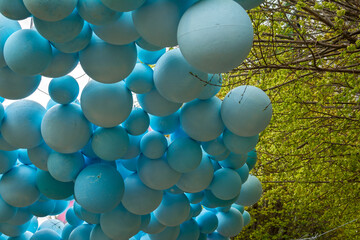 Hanging decorative plastic balls from a tree in sidewalk
