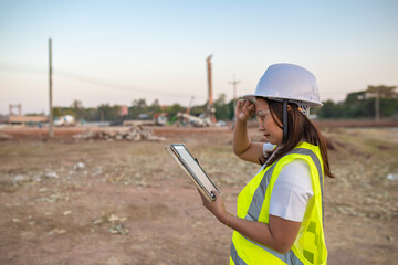 Fototapeta premium Asian engineer working at site of a large building project,Thailand people,Work overtime at construction site