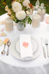 Festive table setting with rose petals. Summer dinner in nature.
