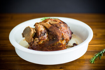 baked pork shank with spices in ceramic form