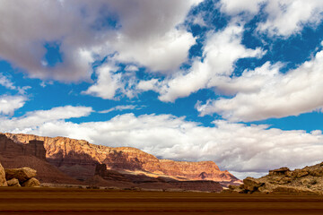 Wide open skies and red rock mountains with white clouds near Navajo bridge, AZ, USA