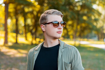 Portrait of handsome young stylish man with sunglasses standiing outdoor.