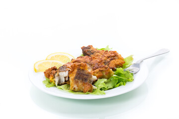 fried hake fish in batter with lettuce and lemon in a plate