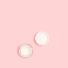 Face cream on a pink pastel background. Beauty products layout with copy space.