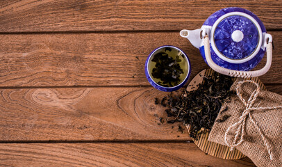 Dry green tea leaves teacup and hot ceramic teapots on wooden background. This is a very useful...