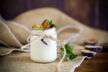 Homemade sweet yogurt with slices of ripe plums in a glass