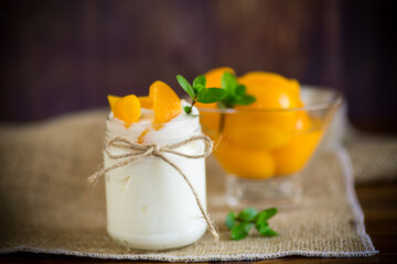 homemade sweet yogurt with slices of pickled peaches in a glass jar