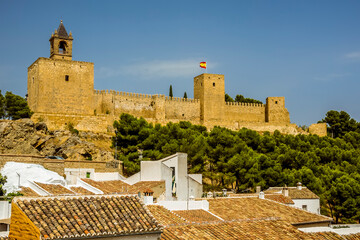 Fototapeta na wymiar A view over the rooftops towards the Alcazaba of Antequera, Spain on a summers morning