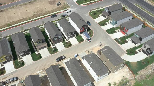 Moving van in front of house in new suburban subdivision still under construction
