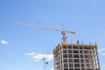 Construction at the background of blue sky. Rresidential building. Reinforced concrete frame of the building.