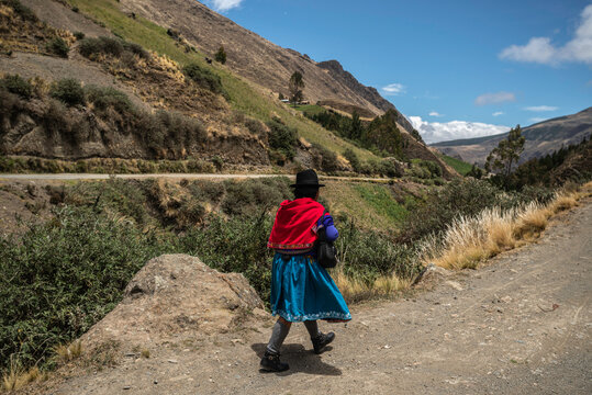Indigenous women of Ecuador walking along the mountain landscape
