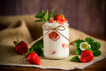 sweet homemade yogurt with ripe fresh strawberries in a jar