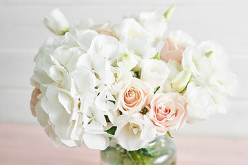 Bouquet of roses, eustomas and hydrangeas on table. Cup of tea and photo frame. Greeting card for mothers day. Cozy good morning. Happy Birthday. Wedding invitation. Flowers composition for Valentine
