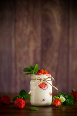 sweet homemade yogurt with ripe fresh strawberries in a jar