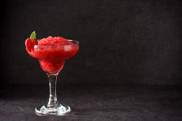 Strawberry margarita cocktail in glass on black background.Copy space
