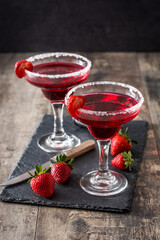 Strawberry red cocktail in glass on wooden table